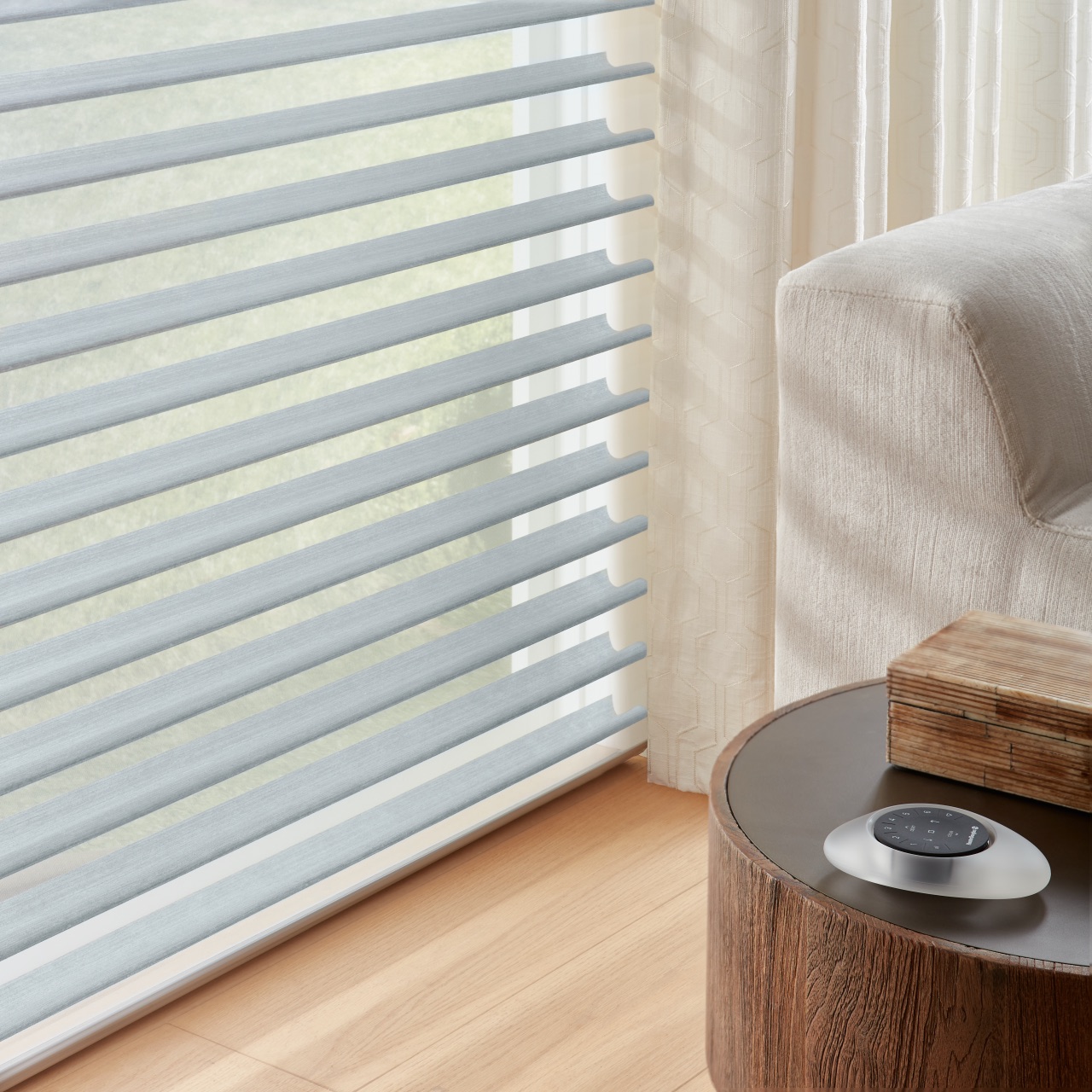 Nantucket™ Window Shadings in a close-up window detail beside a light upholstered chair and wood side table