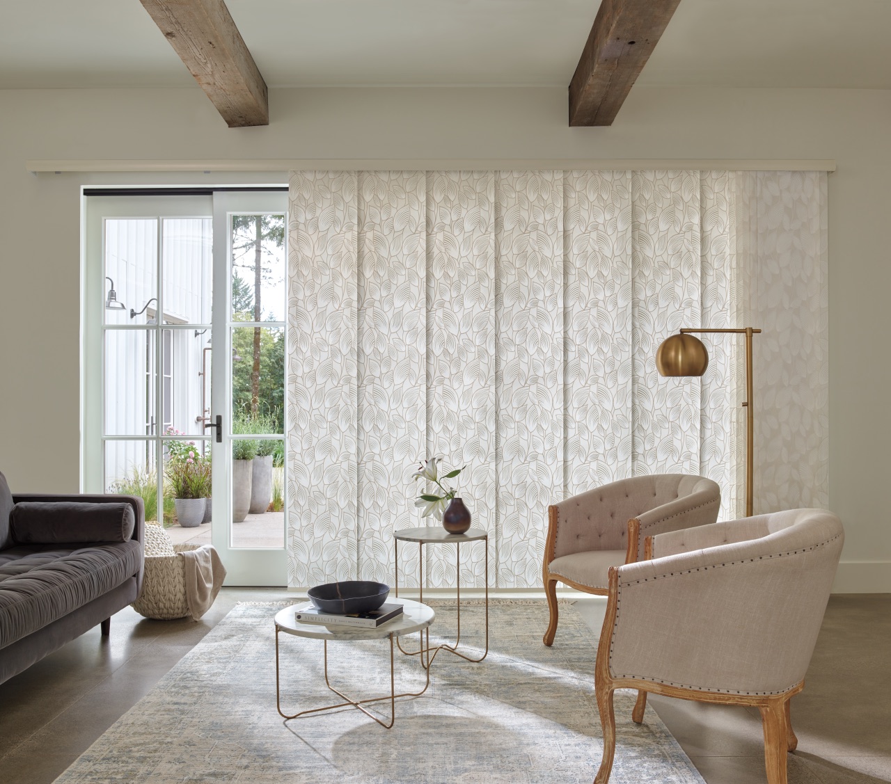 Skyline® Gliding Window Panels spanning a bright dining area and corner window wall with soft taupe panel fabric