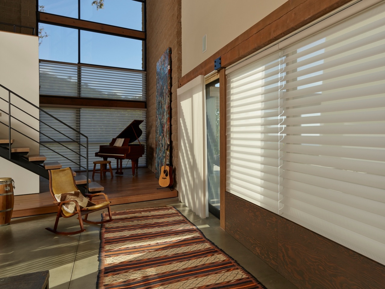 Luminette® Privacy Sheers covering a wide glass opening beside Silhouette® Window Shadings in a warm modern room