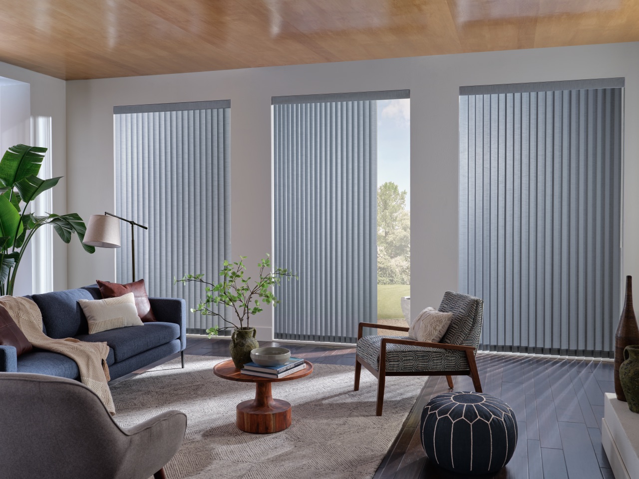 Somner® Custom Vertical Blinds in a bright art studio with white vertical vanes across a large sliding glass opening