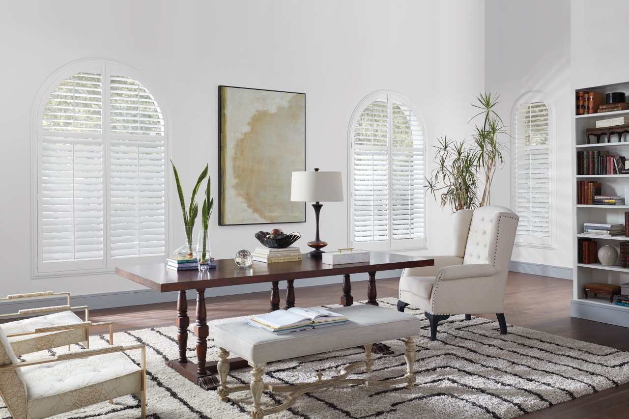 NewStyle® Hybrid Shutters in a bright refined room with arched windows and classic white shutter panels
