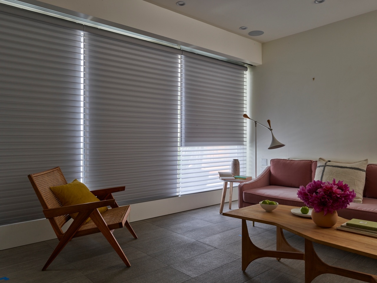 Silhouette® Window Shadings filtering daylight across a warm modern living room with expansive glass and soft neutral finishes